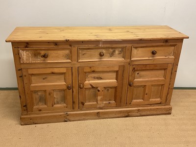 Lot 605 - A pine sideboard with three drawers above...