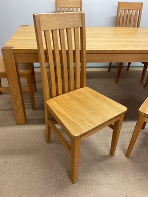 Lot 581 - A contemporary light oak dining table and six...