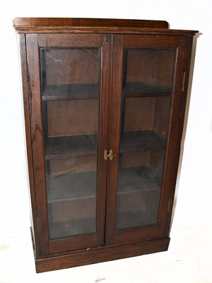 Lot 1592 - A 1920s oak two door bookcase, on plinth base,...