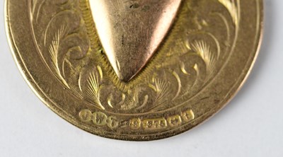 Lot 1124 - A 9ct gold medal with vacant shield-shaped...