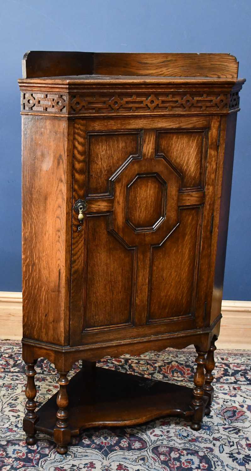 Lot 29 - An early 20th century oak corner cupboard on...