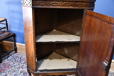 Lot 29 - An early 20th century oak corner cupboard on...