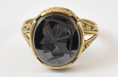 Lot 950 - A 9ct yellow gold ring set with small black...