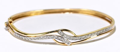 Lot 1096 - A 9ct yellow gold diamond set thin oval hinged...