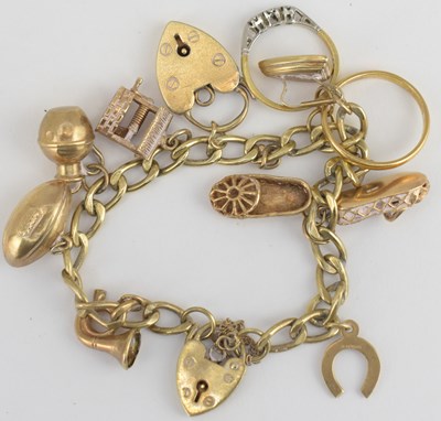 Lot 890 - A 9ct gold charm bracelet with nine charms...