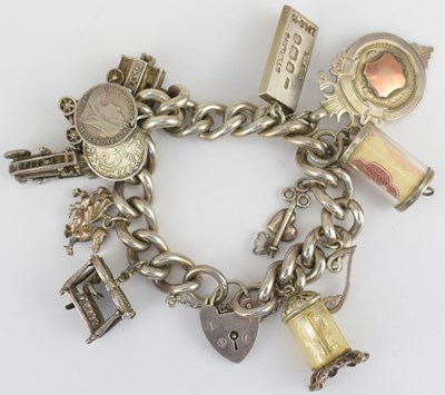 Lot 946 - A hallmarked silver charm bracelet with eleven...