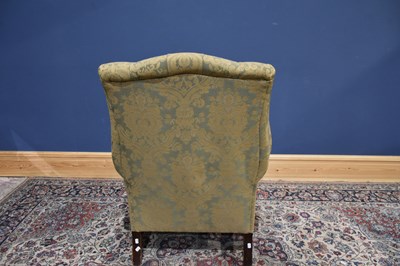 Lot 45 - A reproduction wing back armchair on square...