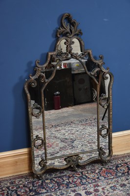 Lot 111 - A modern wall mirror of shaped form with...