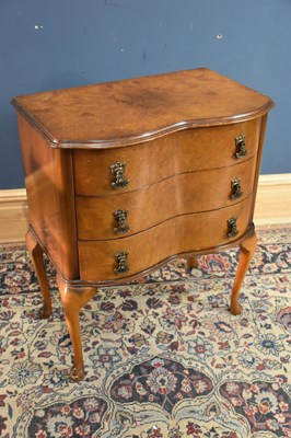 Lot 139 - A 1950s walnut veneered serpentine fronted...