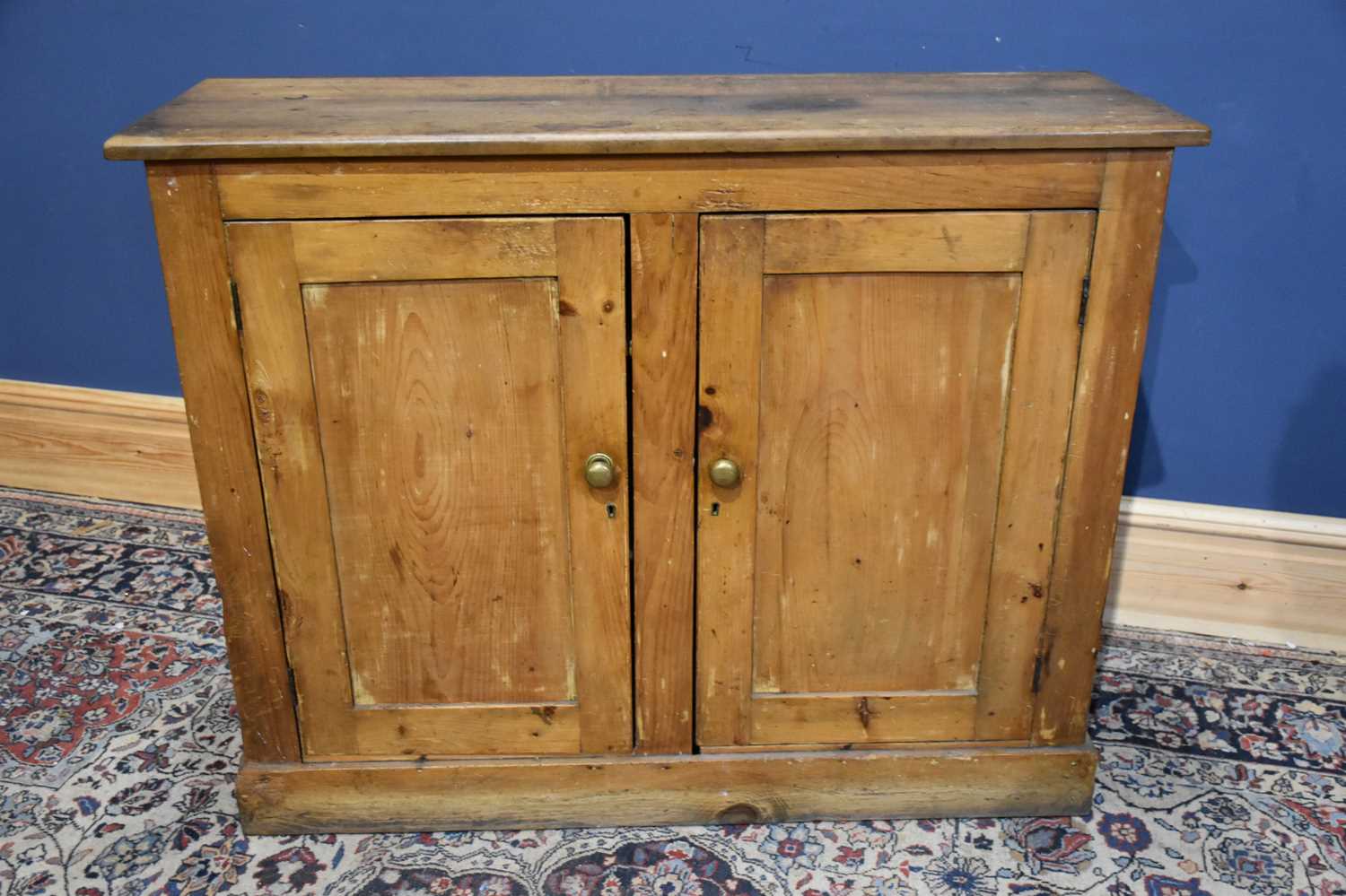 Lot 292 - A Victorian pine two door cupboard on plinth...