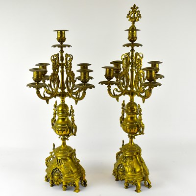 Lot 128 - A pair of ornate brass five branch candelabra,...