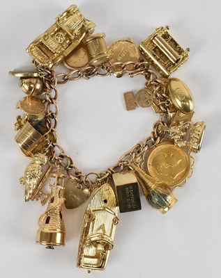 Lot 780 - A 9ct yellow gold charm bracelet with an...