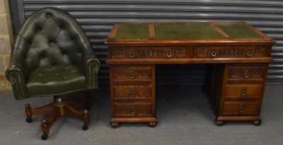 Lot 22 - A reproduction carved oak twin pedestal desk...