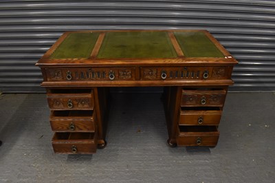 Lot 22 - A reproduction carved oak twin pedestal desk...