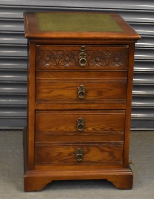 Lot 90 - A reproduction carved oak filing cabinet with...