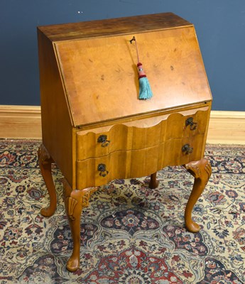 Lot 125 - A 1950s walnut veneered bureau, the fall front...