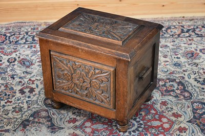 Lot 152 - A 1920s carved oak sewing box, the hinged...