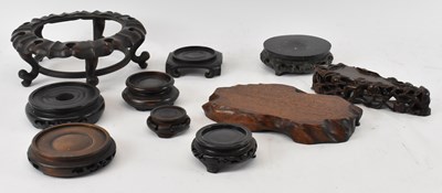 Lot 564 - A group of nine Chinese carved hardwood stands...