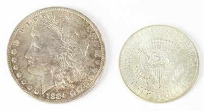 Lot 692 - An 1884 US silver dollar and a US 1964 half...