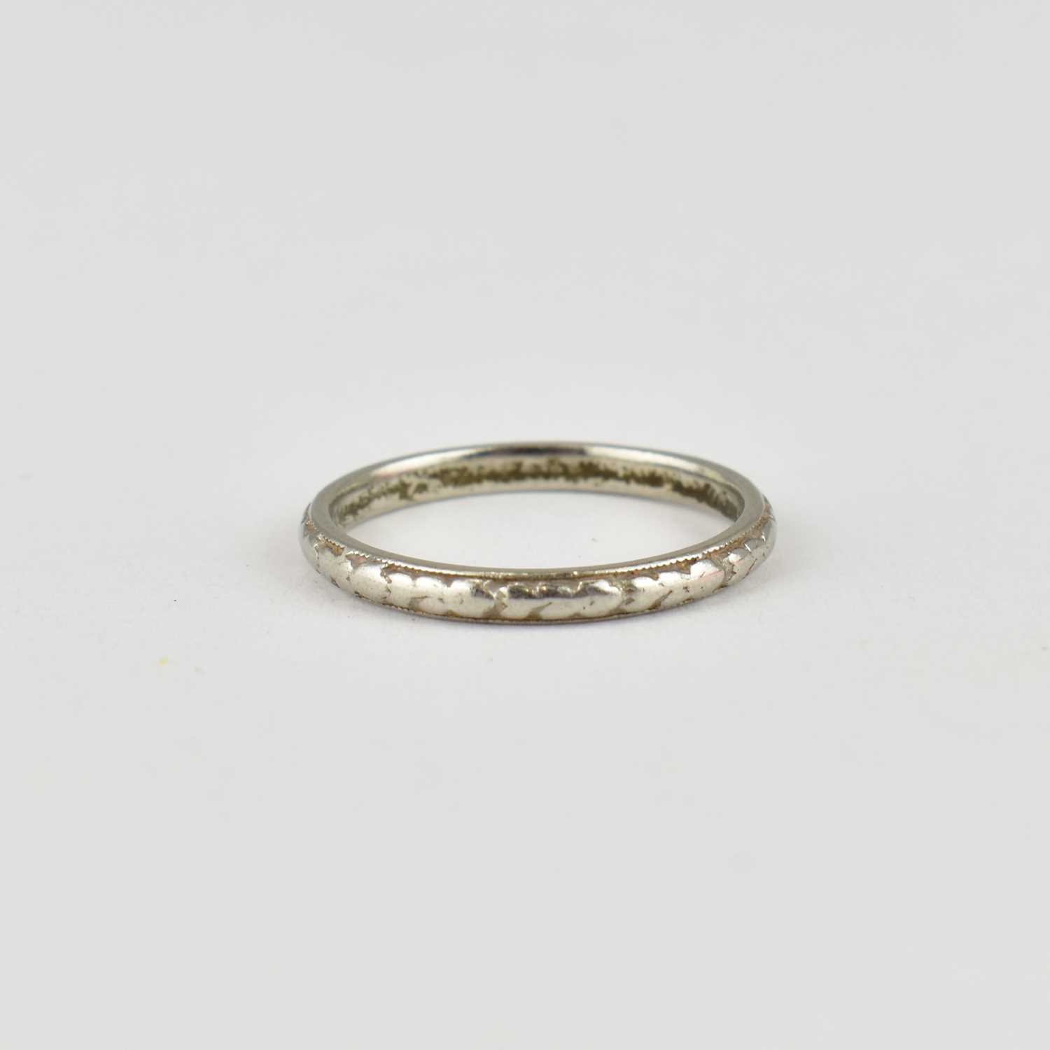 Lot 712 - A platinum thin band ring with repeating...