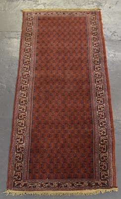 Lot 119 - A Persian red ground runner with geometric...