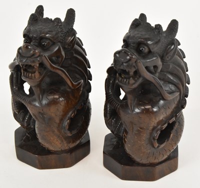 Lot 641 - A pair of carved hardwood netsukes of dragons,...