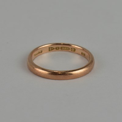 Lot 782 - A 9ct rose gold thin wedding band, size L,...