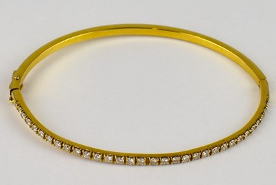 Lot 797 - An 18ct gold thin hinged bracelet, the front...