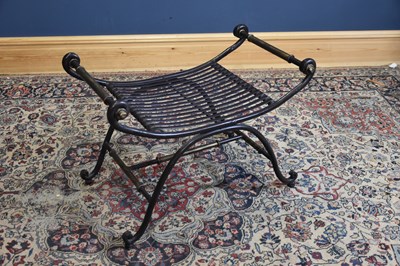 Lot 211 - A decorative metal X-frame stool, width 77cm.