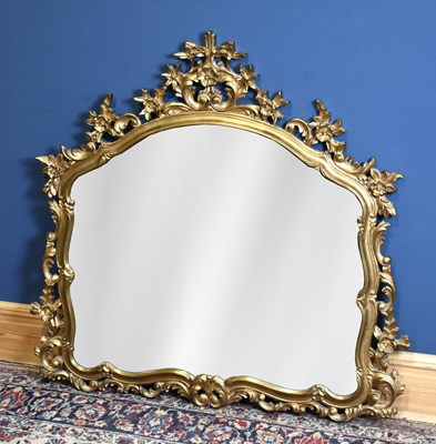 Lot 206 - A modern ornate gilt wall mirror with floral...