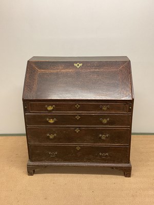 Lot 701 - A George III oak bureau with four graduated...