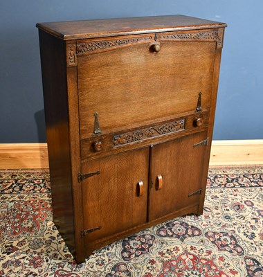 Lot 276 - A 1930s carved oak secretaire, with fall front...