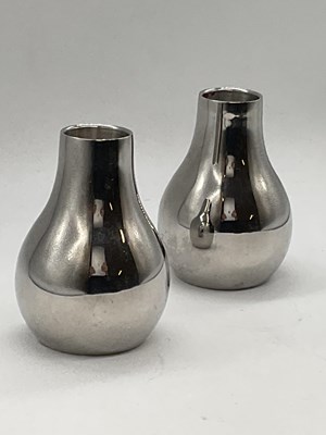 Lot 136 - GEORG JENSEN; a pair of stainless steel candle...