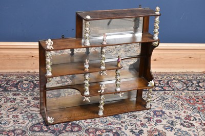 Lot 51 - A walnut mirrored back set of shelves with...