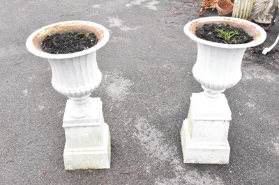 Lot 371 - A pair of cast iron urns on stands (af),...