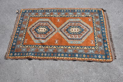 Lot 457 - An orange ground Eastern style wool rug with...