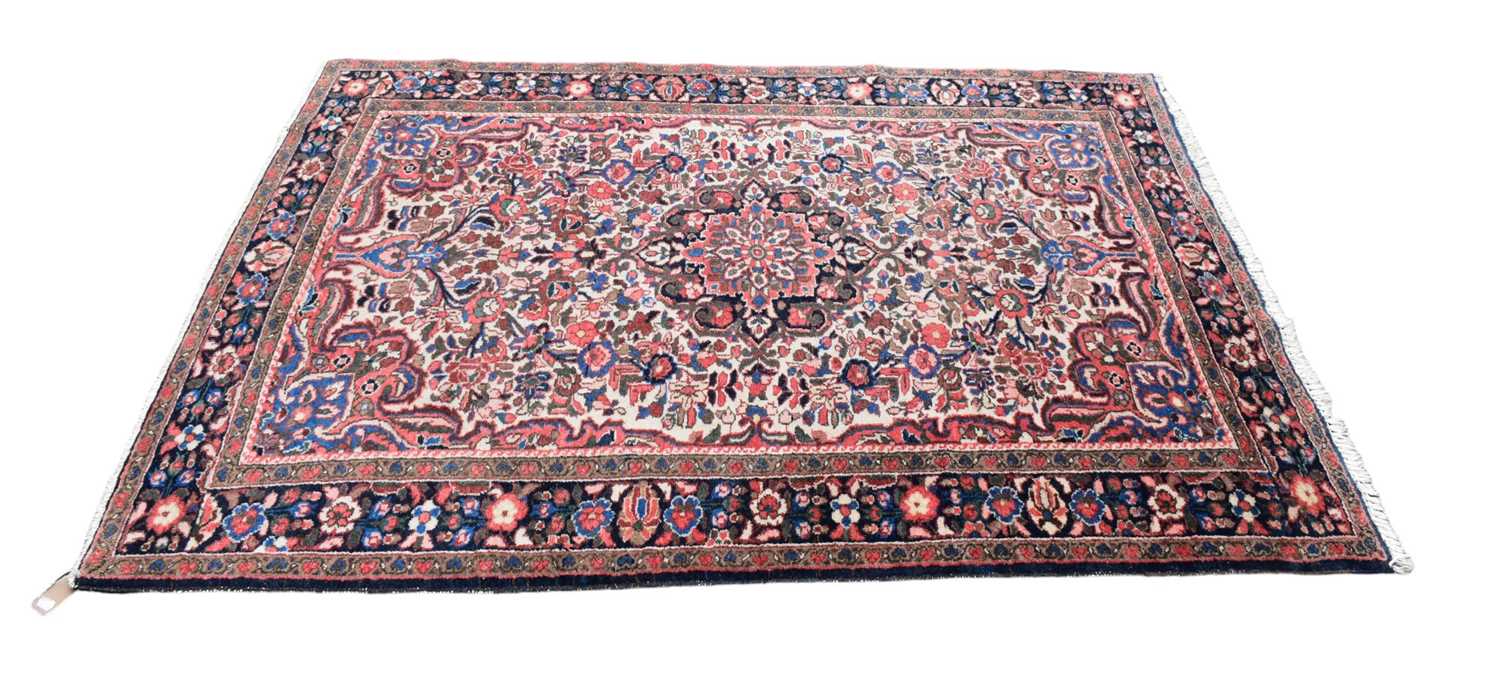 Lot 352 - An Eastern style blue ground rug with floral