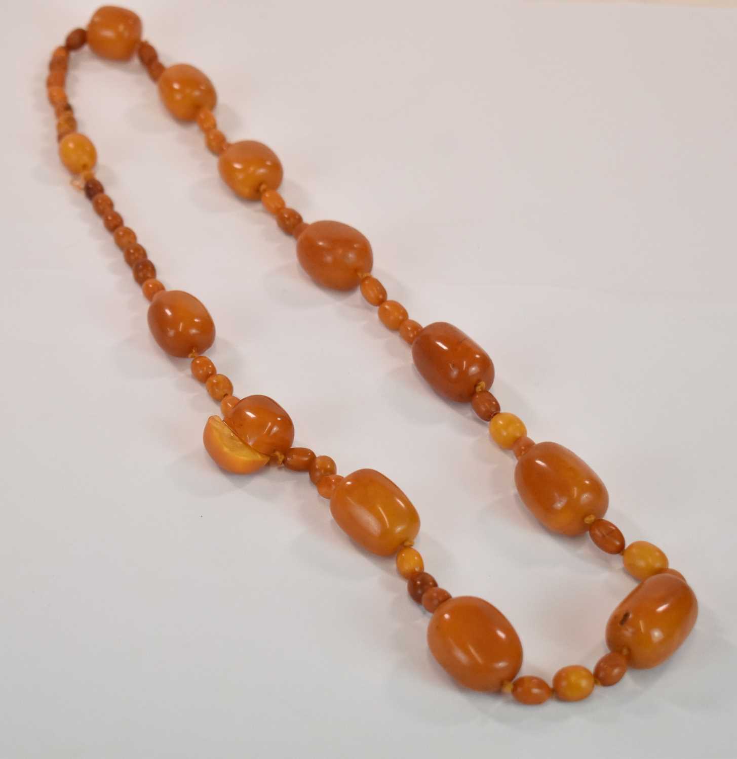 Lot 1269 - An early egg yolk/butterscotch amber bead...