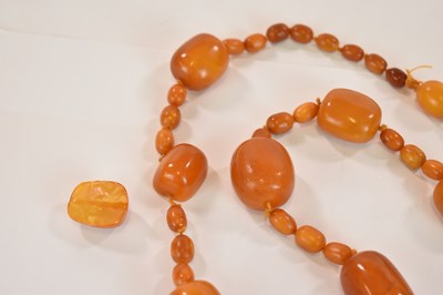 Lot 1269 - An early egg yolk/butterscotch amber bead...