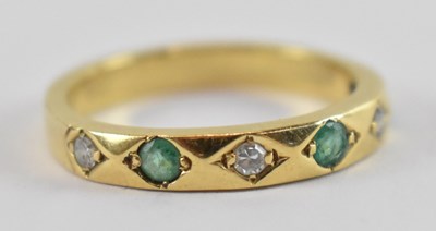 Lot 667 - A yellow metal diamond and emerald ring, set...