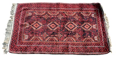 Lot 334 - A Tekke designed red ground rug with lozenge...