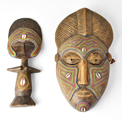 Lot 90 - A carved wooden mask decorated with beads and...