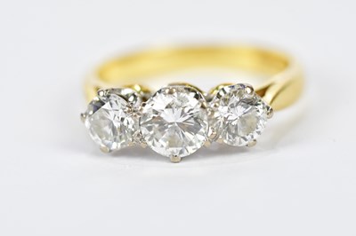 Lot 55 - An 18ct yellow gold three stone diamond ring,...