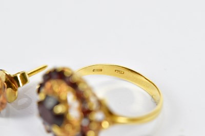 Lot 82 - An 18ct yellow gold garnet set dress ring,...