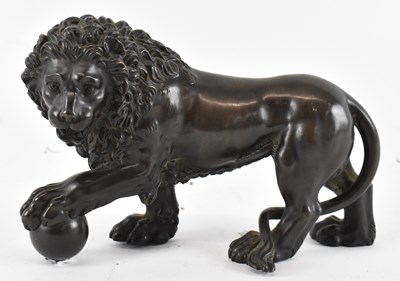 Lot 568 - A bronze model of a lion with a ball in its...