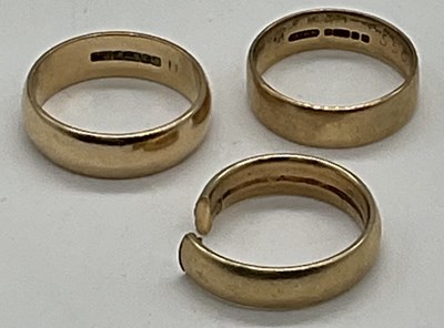 Lot 475 - Three 9ct yellow gold wedding bands (one cut),...