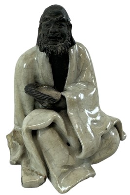 Lot 1165 - A Chinese figure of a beggar, draped in...