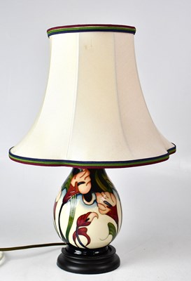 Lot 355 - MOORCROFT; a cream ground floral table lamp...