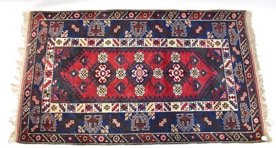 Lot 63 - An Eastern hand knotted red and blue ground...