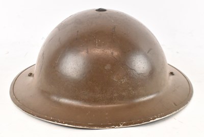 Lot 394 - A WWII period helmet with canvas chin strap...